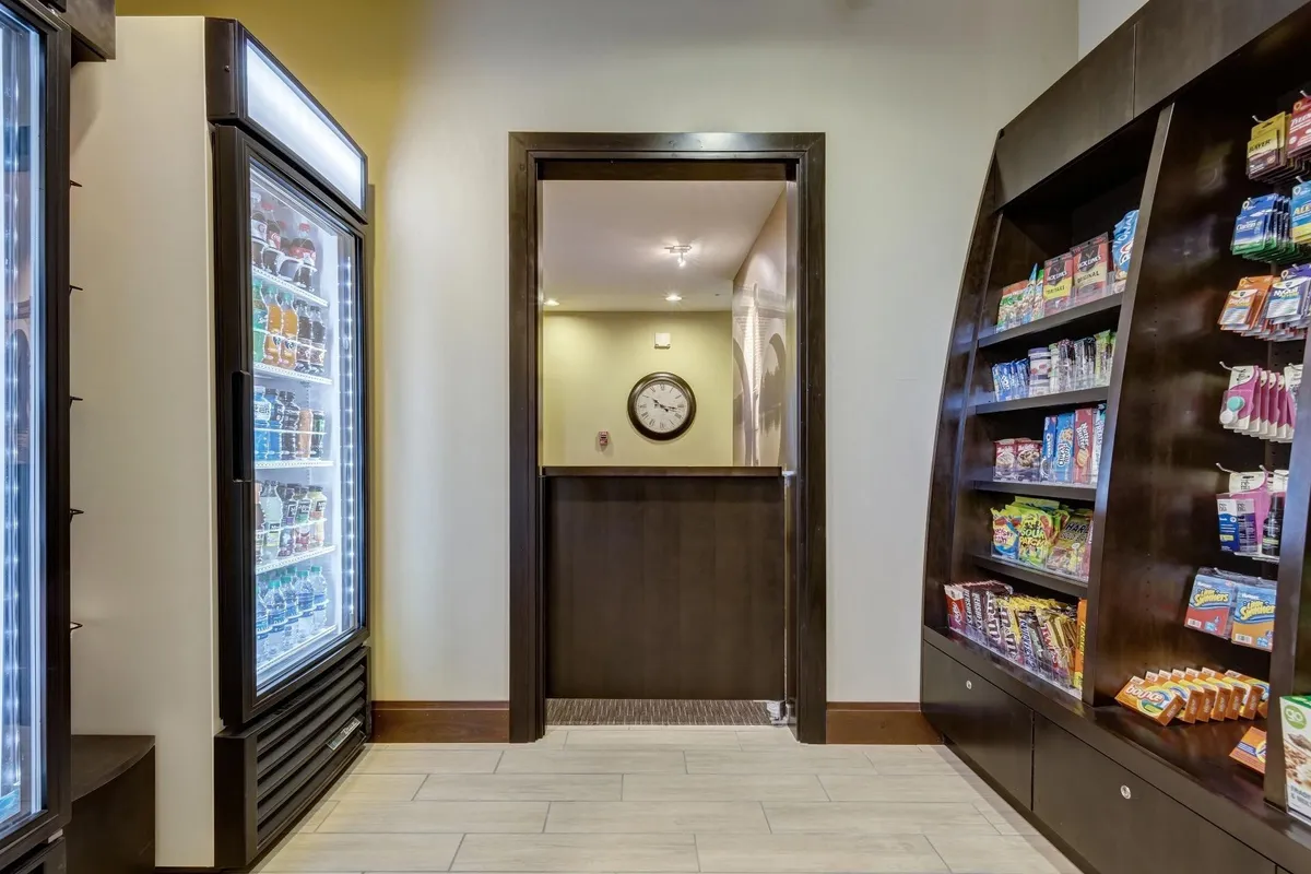A casual snack and beverage area with a refrigerated display, snack shelves, and a relaxed atmosphere, perfect for grabbing a quick refreshment during a work or leisure break.